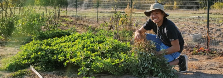 image of Jordan Francisco with peanut plants at the OHIO Student Farm