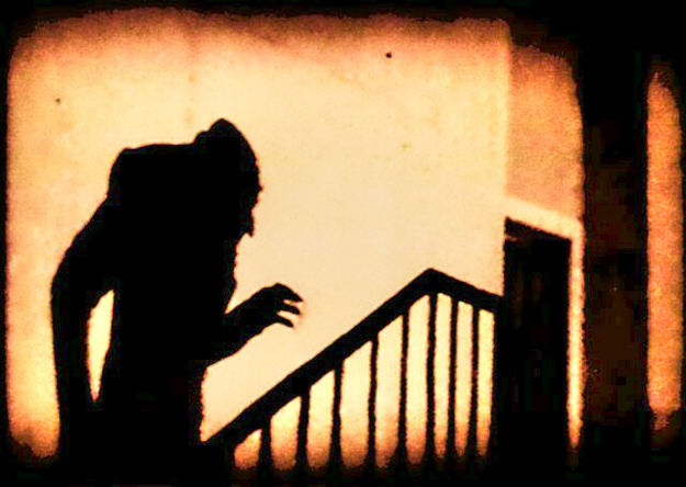 Shadowy image of hunchback with claw-like fingers on a stairwell