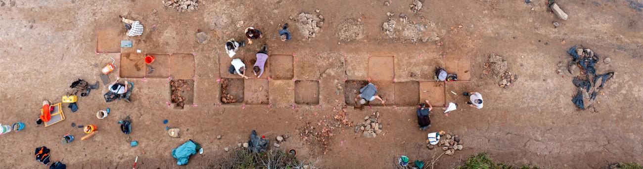Students dig at an archaeological field site.