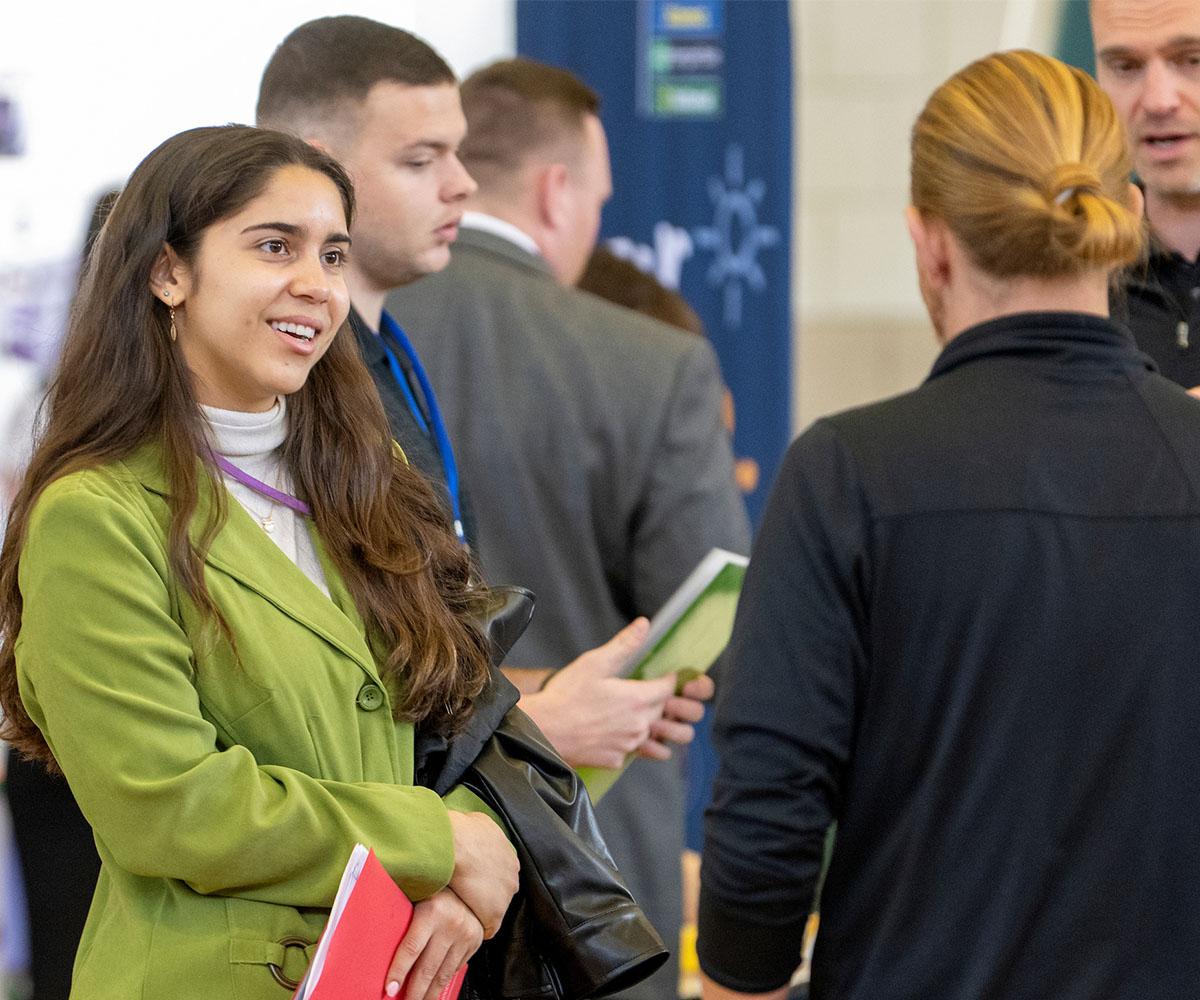 A student talks to a recruiter at a job fair.