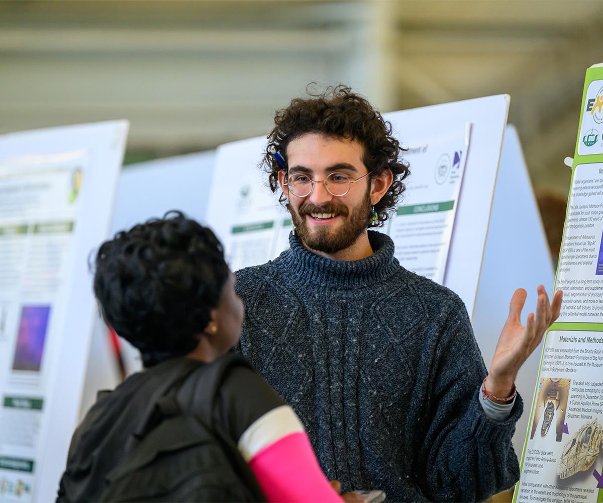 A student talks to another student about their research.