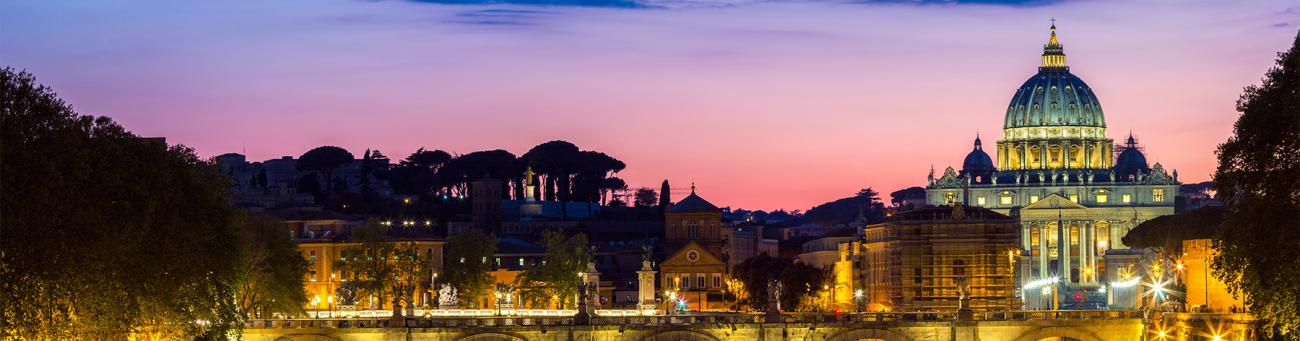 A stock image of St. Peter's Basilica in Vatican City at night.