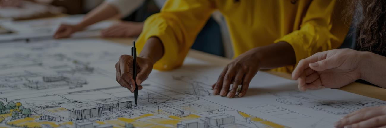 Diverse group of people collaborating on architectural drawings, focusing on urban planning layout