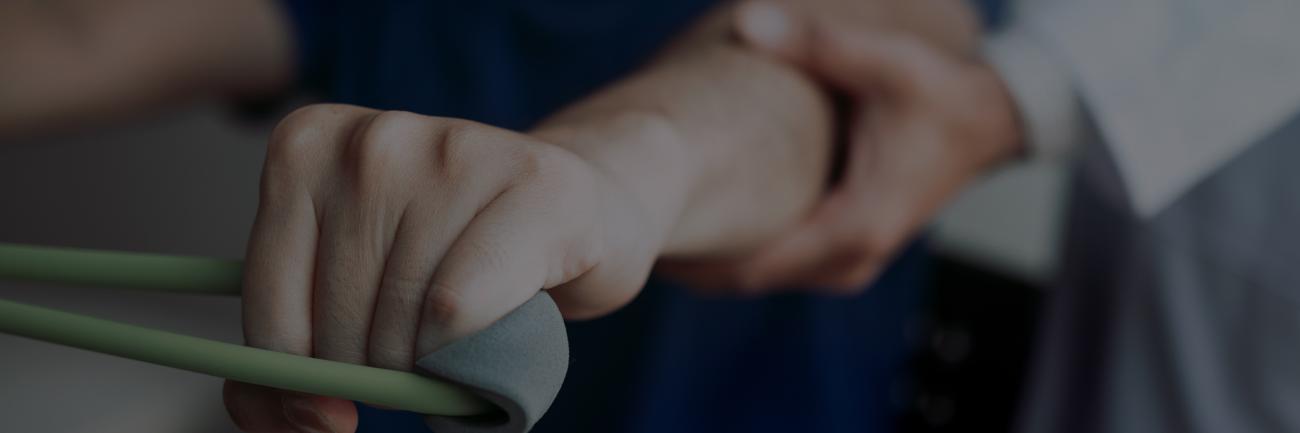 A physical therapist engages a patient in a hand-strengthening activity.