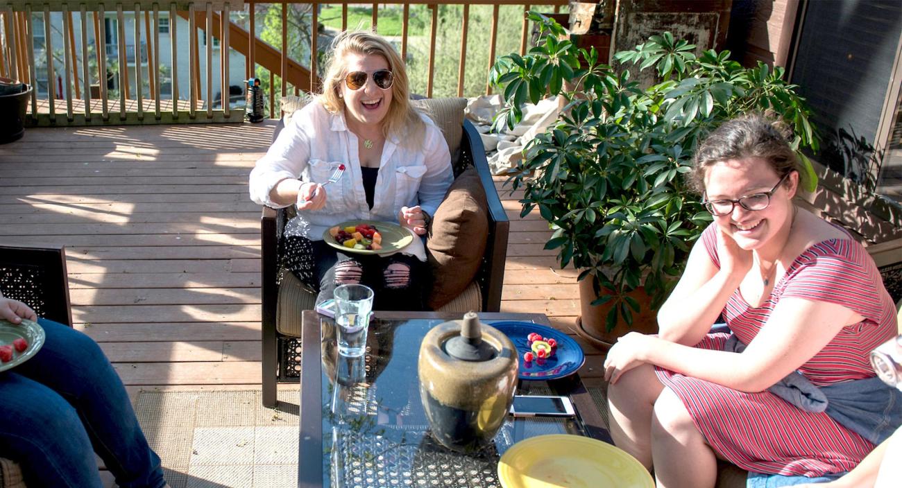 Three Margaret Boyd scholars sit outside on a porch talking