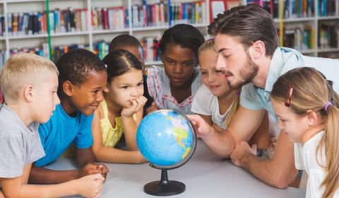 teacher and schoolchildren around a globe