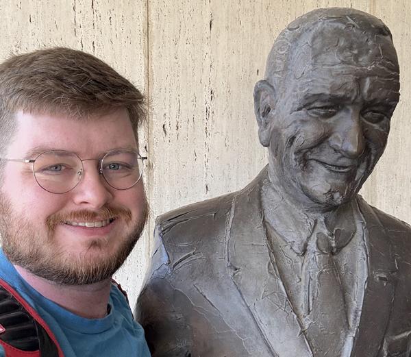 Ethan Tackett with a statue of President Johnson