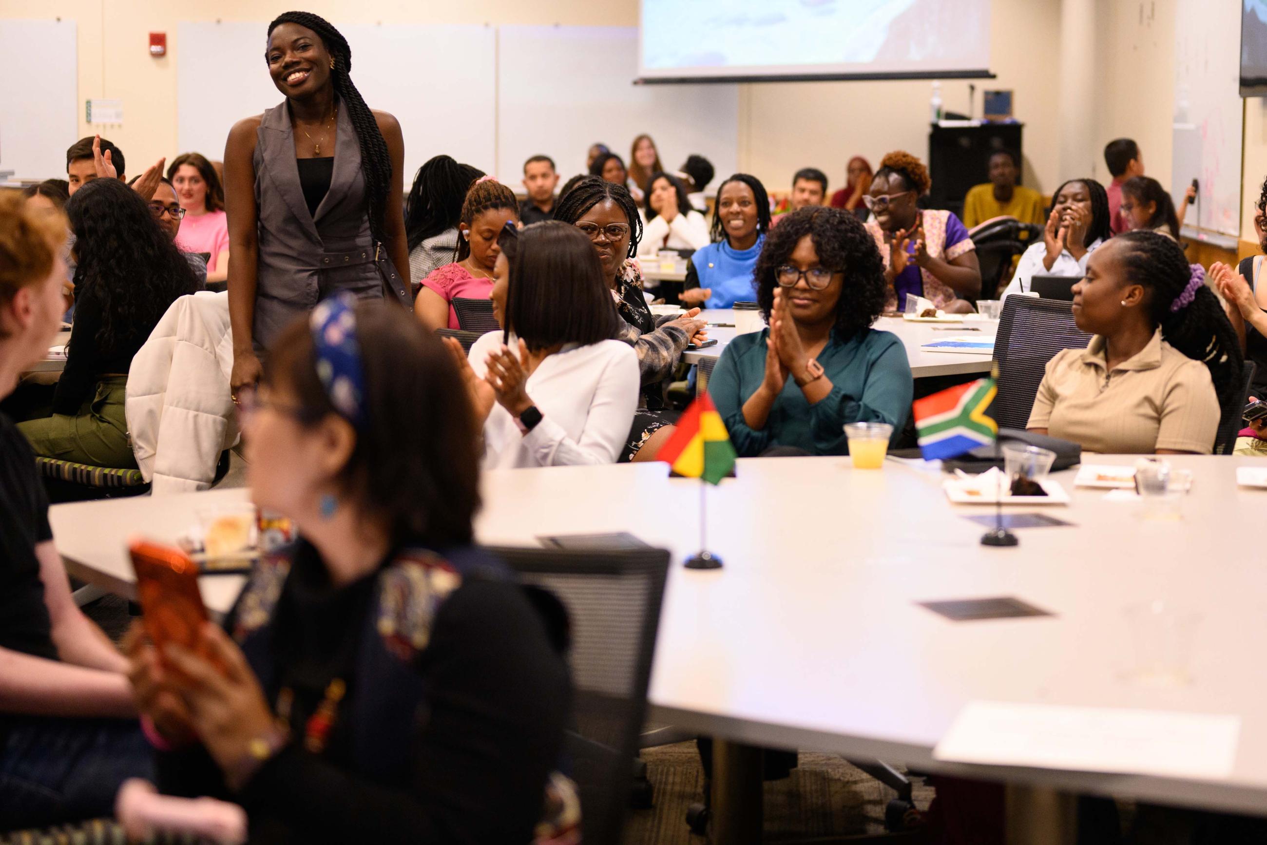 Female student standing and smiling for recognition.