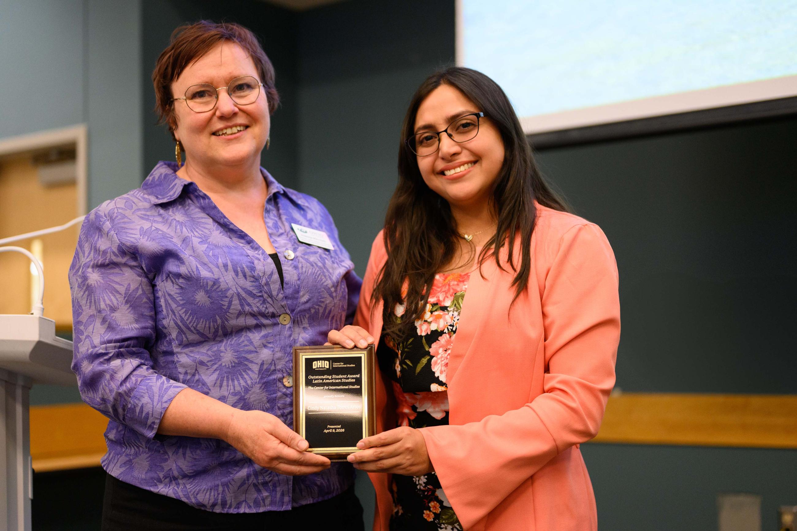 Dr. Joanna Mitchell presenting female student a small plaque.