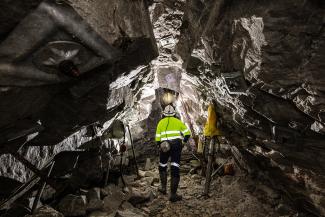 Person in a cave with a reflective workers outfit on