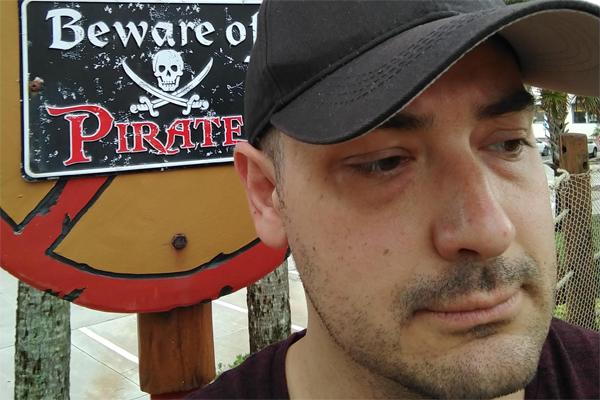 Jeremy Tanner, portrait with sign that reads "Beware of Pirates"