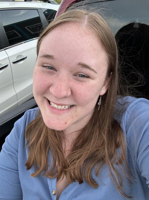 A selfie of Sophie Laich outside near parked cars