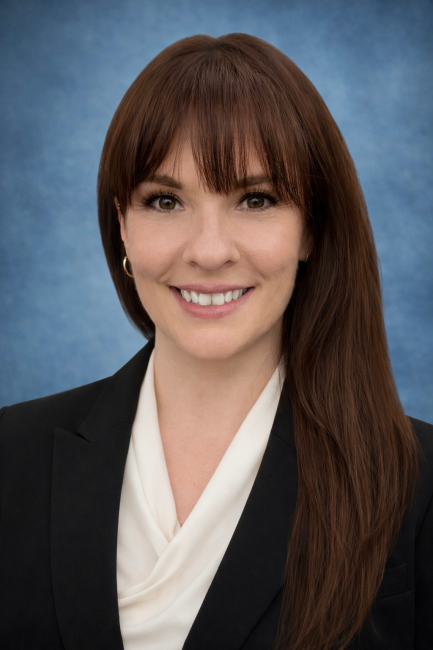 A headshot of Tiffany Sheets, smiling and wearing business clothes.