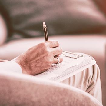 A woman sitting and taking notes during a consultation