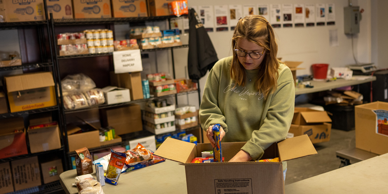 Community Health Worker packs a box at the Foodbank