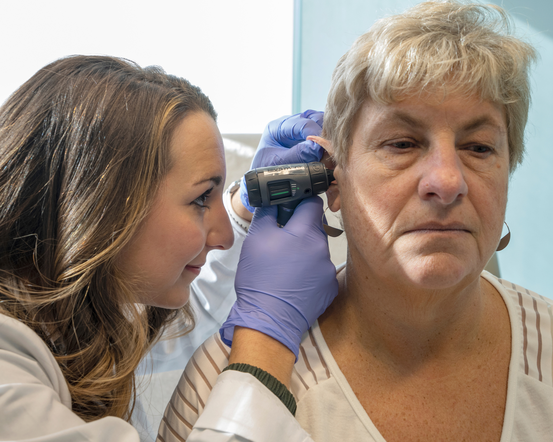 Physician assistant student examining a patient's ear