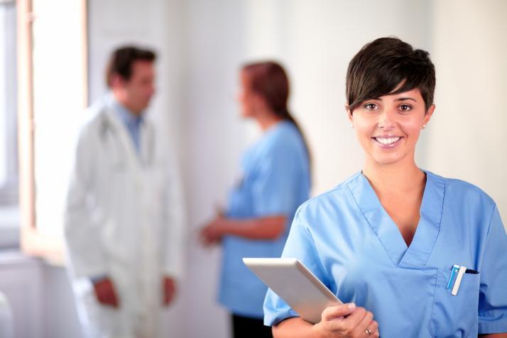 nurse in blue scrubs with short hair