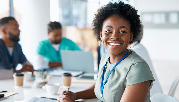 Master of Healthcare Administration student smiling at table with classmates