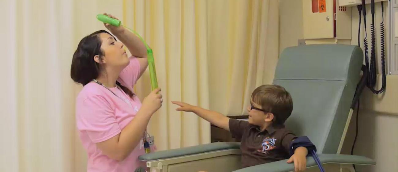 Nurse blowing bubbles with a young patient
