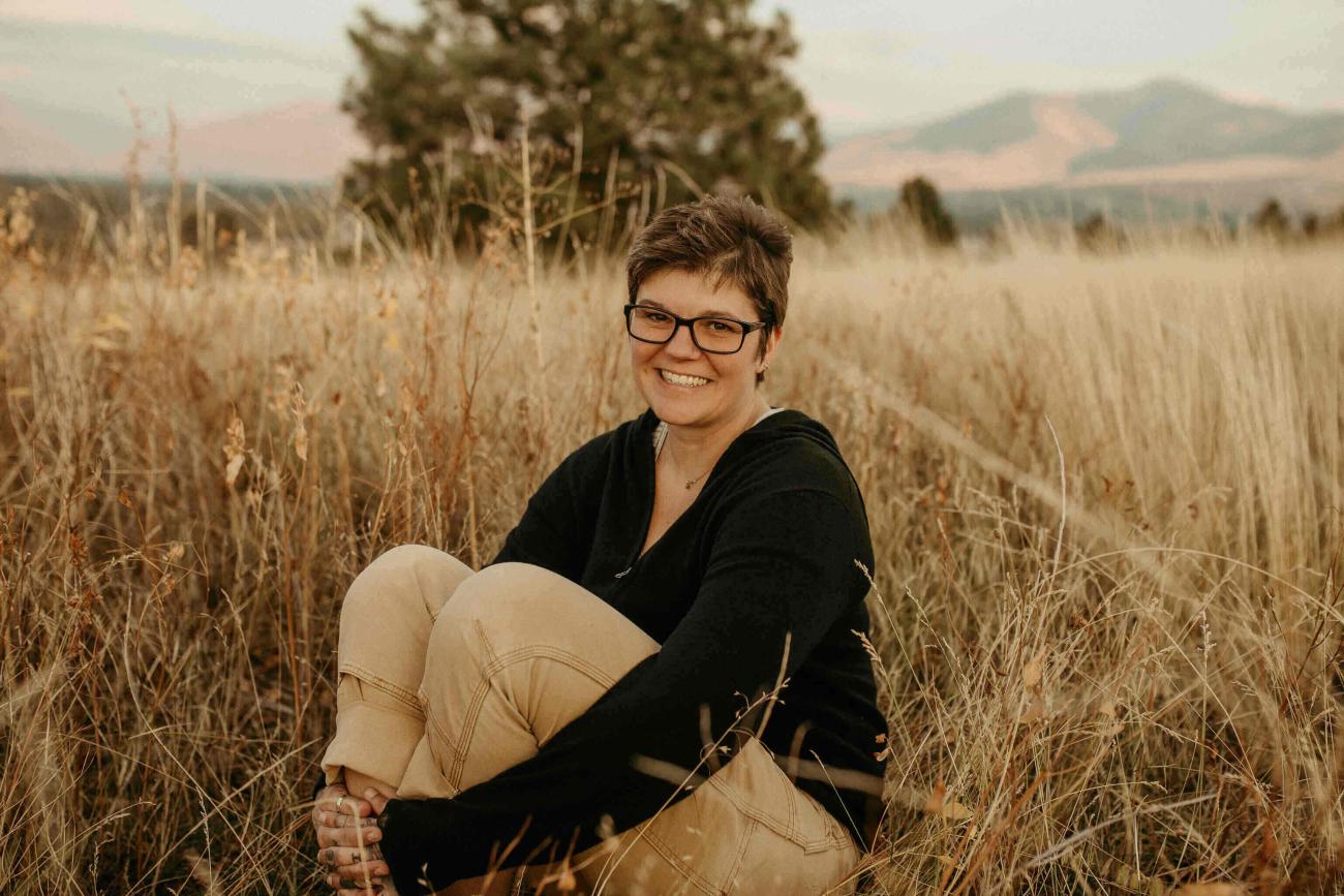 Portrait of Stephanie Land seated in a field of wheat