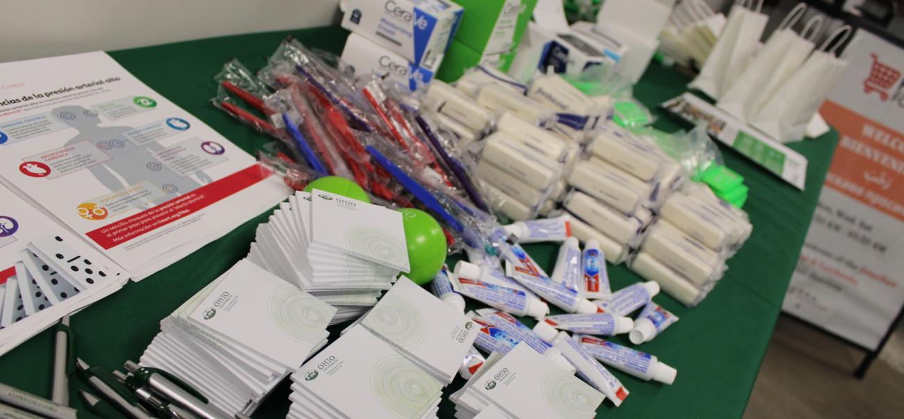 A resource table stocked with toothpaste, toothbrushes, soap, and fliers