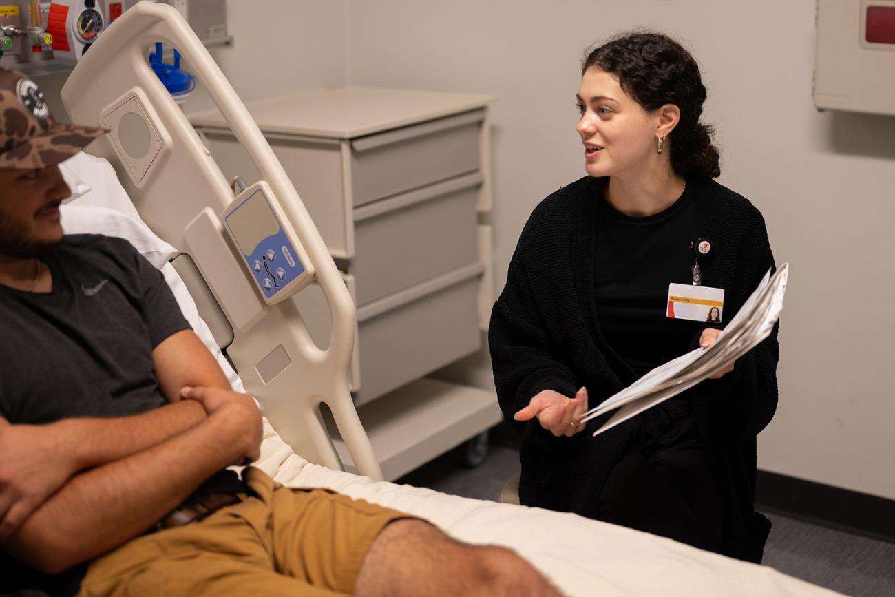 Nutrition Science student showing simulated patient a clipboard