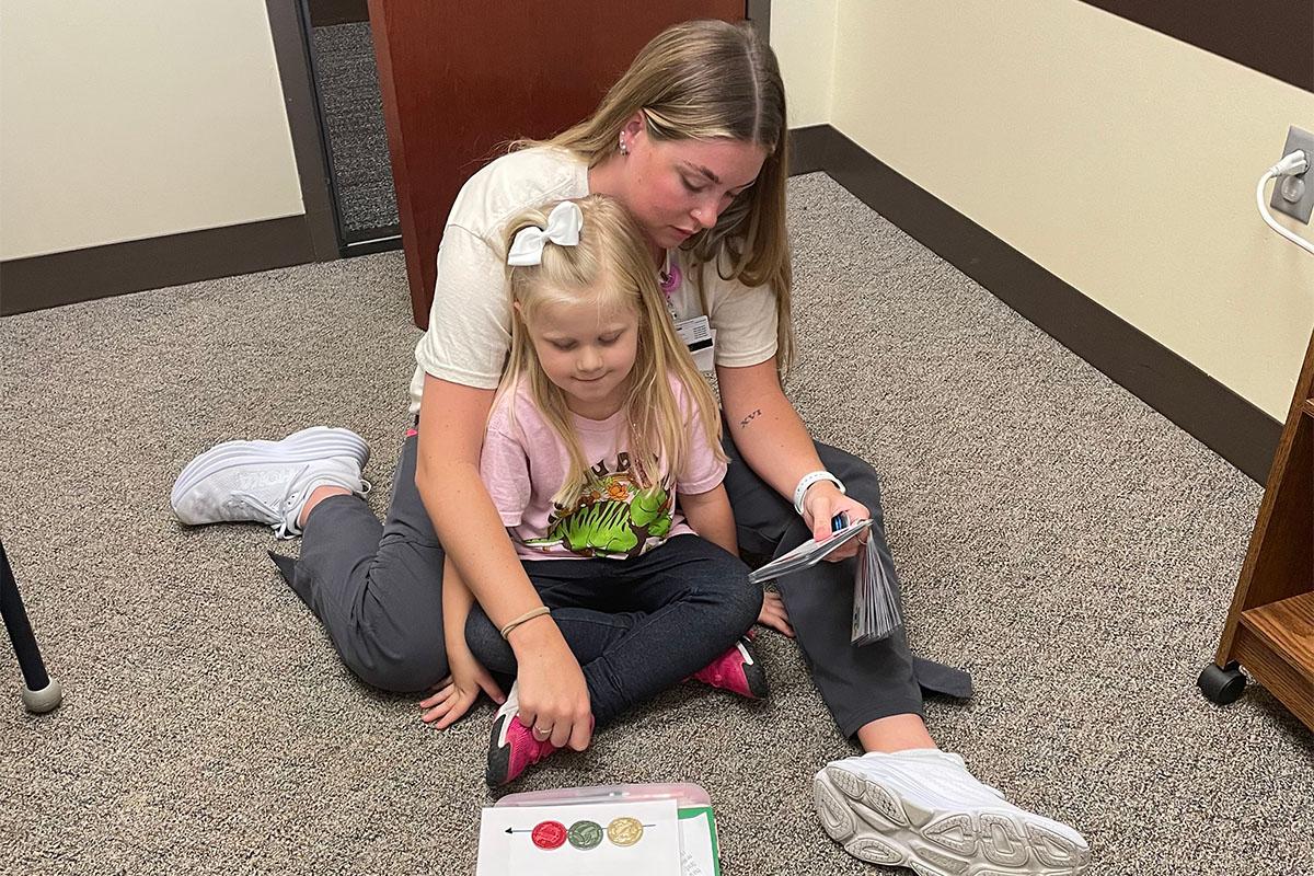 A Speech language pathology graduate student does an activities with a child in the PALS program.