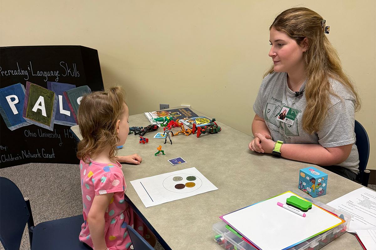 A speech language pathology graduate student does an activity with a child in the PALS program.