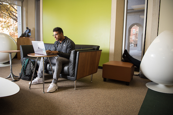 Student in a lounger sitting at a computer