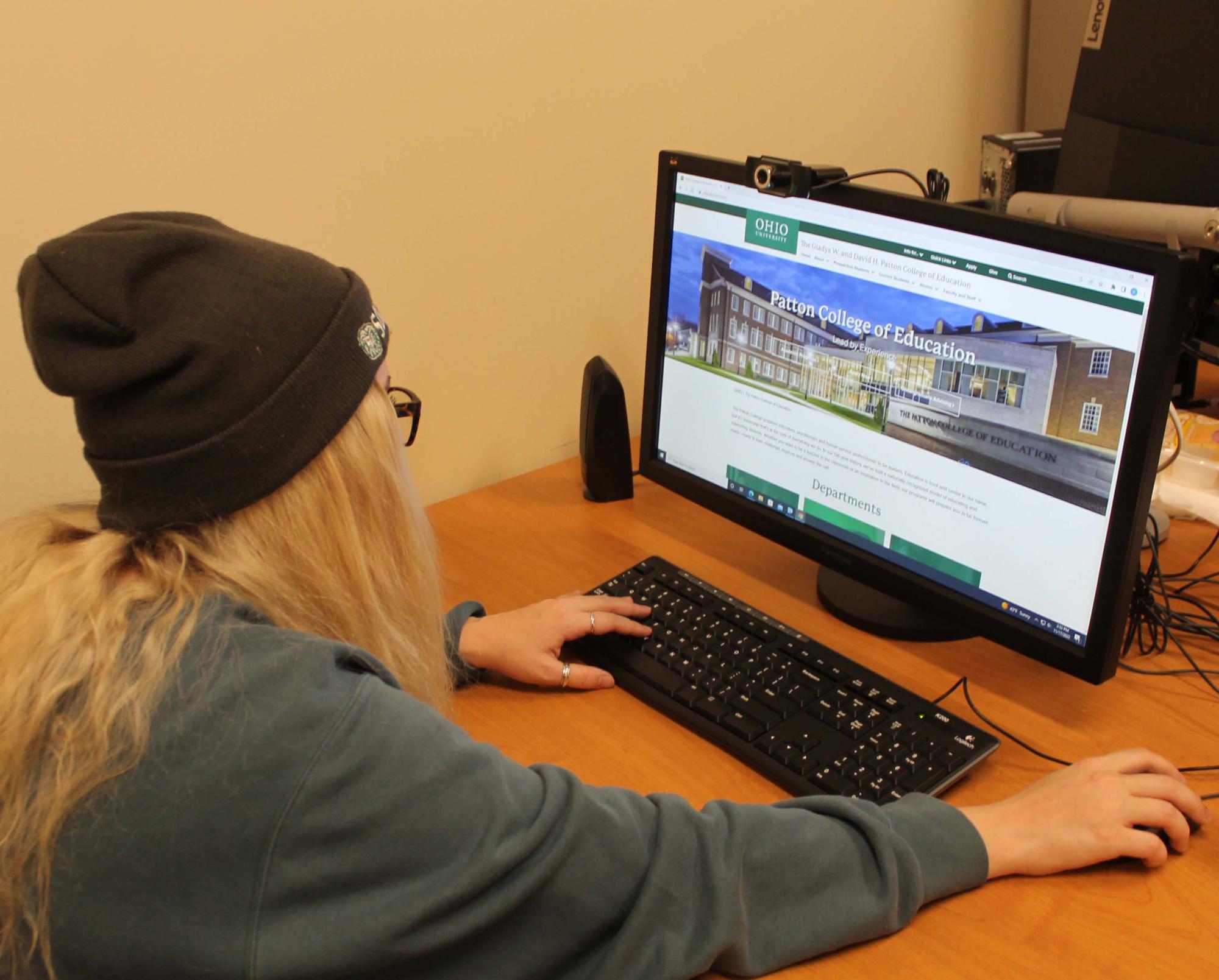 Student looking at the Patton College of Education homepage on a desktop computer