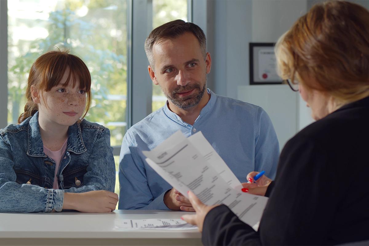 A principal meets with a parent and student.
