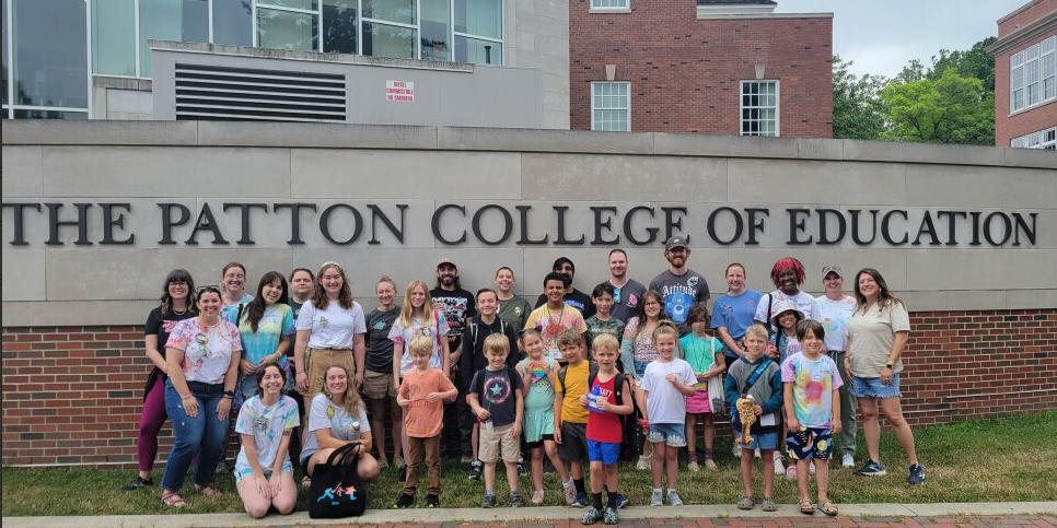 Stevens Center students and teachers posing in front of the Patton College of Education sign.