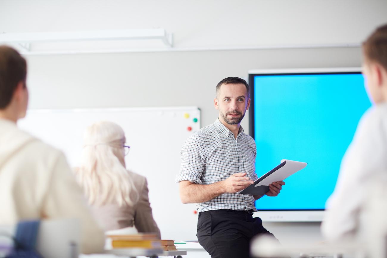 man standing in front of classroom of adults
