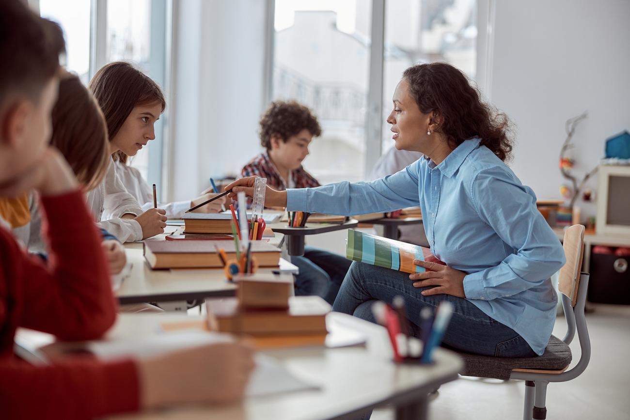An elementary teacher works with students in a classroom