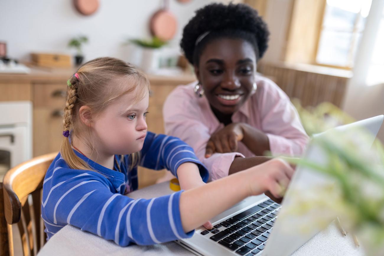 A child with down syndrome having a lesson with her teacher