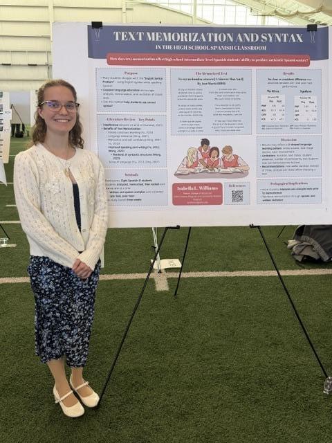a student standing next to their expo research poster