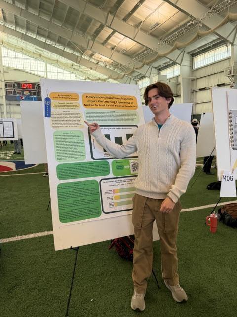 a student standing next to their expo research poster