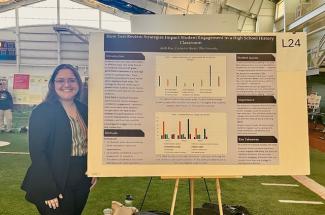 Student standing next to a presentation