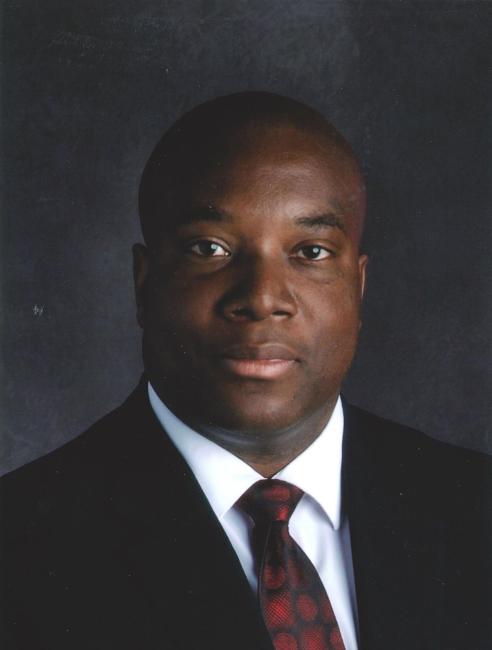 Headshot of Milton Folson wearing a suit and tie