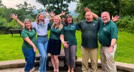 Photo of Patton College advisors posing outside with arms out 