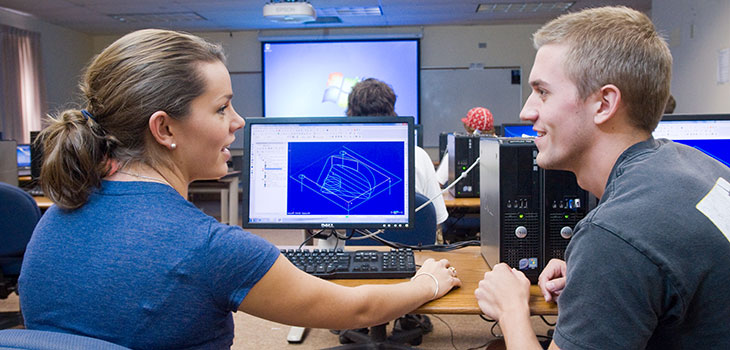 Man and woman in front of a computer in a lab
