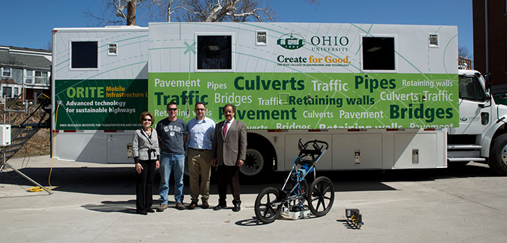 Four people posing in front of a trailer painted with the label "ORITE Mobile Infrastructure Lab"