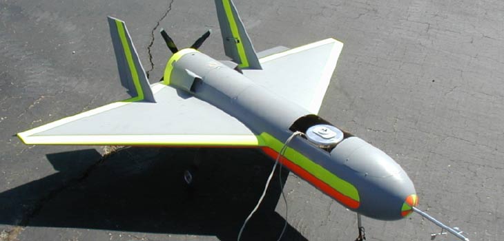 Brumby UAV parked on landing strip, with wires extending from open top hatch