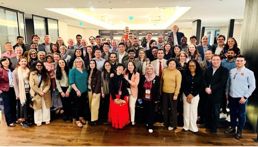 Over 80 alumni, students, and friends of the ICMT posing during a reception