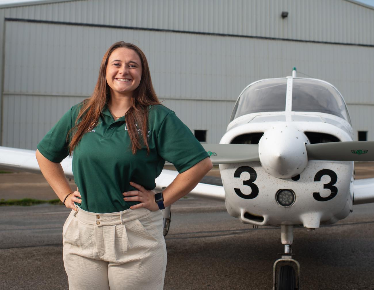 Aviation student poses with an Ohio University airplane