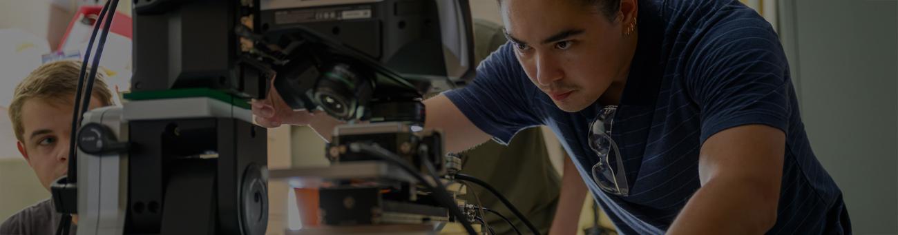 Two students work closely on a task in an engineering lab.