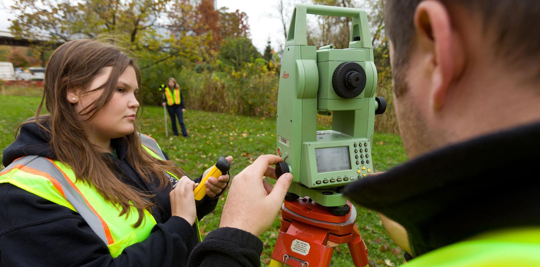 Working with surveying equipment in the field.