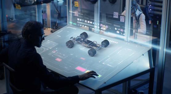 Electrical engineer at workstation with autonomous unmanned vehicle model on screen