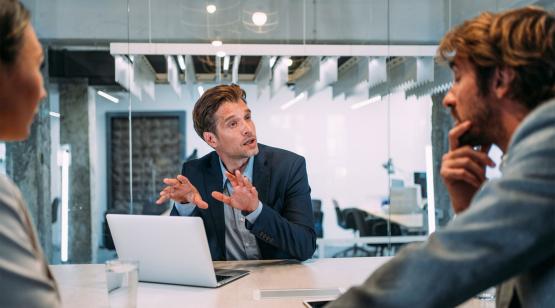 Electronic navigation students around table discussing certification
