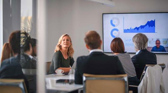 Faculty of engineering programs around board room table reviewing graphs on screen